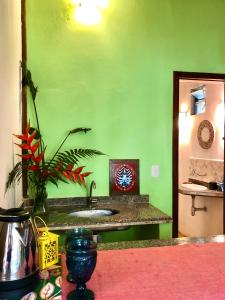 een groene badkamer met een wastafel en een groene muur bij Gaia Eco Glamping - Instituto Almas Livres in Arraial d'Ajuda
