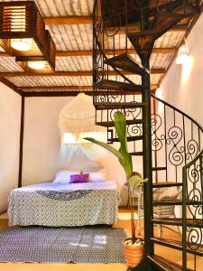 a bedroom with a bed and a spiral staircase at Gaia Eco Glamping - Instituto Almas Livres in Arraial d'Ajuda