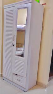 a white cabinet with a mirror in a room at Welcom Tourist Hostel in Dubai