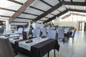 - une salle à manger avec des tables, des chaises et des bouteilles de vin dans l'établissement Chalet Madonna di Viggiano, à Viggiano