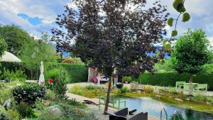 un jardín con un árbol y un estanque en Garden Paradise Bled Apartments - garden, pond and castle view en Bled