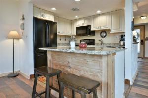 a kitchen with a wooden island with a black refrigerator at Seven Springs 3 Bedrooms Premium Condo, Ski In Ski Out condo in Champion