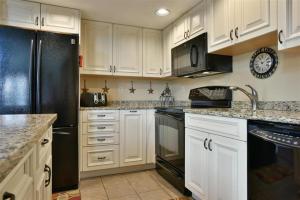 a kitchen with white cabinets and a black refrigerator at Seven Springs 3 Bedrooms Premium Condo, Ski In Ski Out condo in Champion