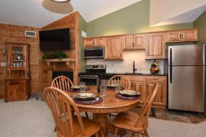 a kitchen with a wooden table with chairs and a refrigerator at Seven Springs 1 Bedroom Premium Condo, Ski In Ski Out condo in Champion