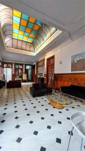a large living room with a piano and stained glass ceilings at 1900 Hostel in Lima
