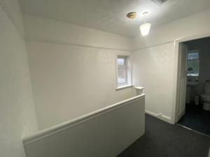 a white room with a toilet and a window at Home Away From Home Near Derby City Centre - Sleep upto 7 in Derby