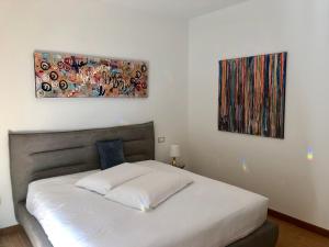 sypialnia z łóżkiem i dwoma obrazami na ścianie w obiekcie Vistala w mieście Baveno