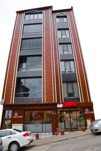 a tall building with cars parked in front of it at Osmanlı Paşa Otel- Konaklama in Samsun