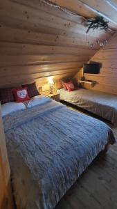 a bedroom with two beds in a log cabin at Staro Chałpa in Istebna