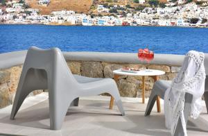 2 sillas y una mesa con vistas al agua en Tohu Villas Mykonos en Ornos