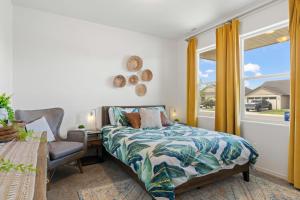 a bedroom with a bed and a chair and a window at The Explorer! Extra Game Room, Fire pit Sleeps 10! in Caldwell