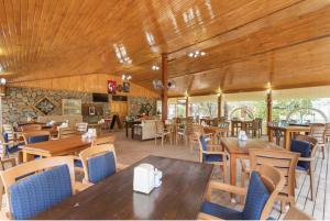 a restaurant with wooden ceilings and tables and chairs at Likya Yanartaş Bungalow in Kemer