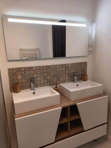 een badkamer met 2 wastafels en een grote spiegel bij Appt centre Gerardmer in Gérardmer