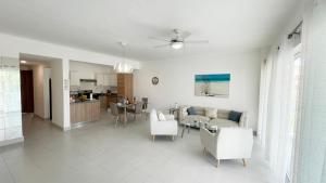 een witte woonkamer met een bank en een tafel bij Precioso Apartamento a solo pasos de la Playa in Punta Cana