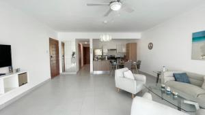 een witte woonkamer met een bank en een tafel bij Precioso Apartamento a solo pasos de la Playa in Punta Cana