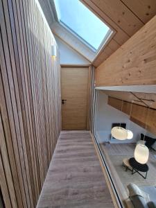 a room with wood paneled walls and a skylight at Duplex type chalet dans le Jura in Morbier