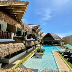 a resort with a swimming pool and straw umbrellas at Bathala Resort in Panglao