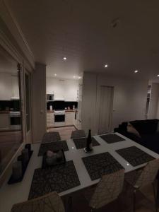 a living room with a table and a kitchen at Topelius Park Apartment in Uusikaarlepyy +4 photos