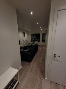 a living room with a black couch and a table at Topelius Park Apartment in Uusikaarlepyy