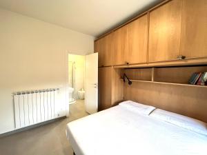 sypialnia z białym łóżkiem i drewnianymi szafkami w obiekcie Arcadia w mieście Levanto +2 zdjęcia