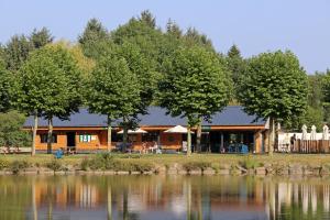 a log cabin next to a lake at Huttopia Baie du Mont Saint Michel in Baguer-Pican