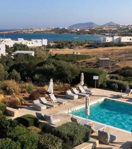 a swimming pool with lounge chairs and umbrellas at Sea Swell Villas at Santa Maria in Santa Maria