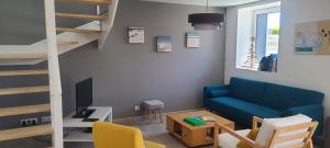 uma sala de estar com um sofá azul e um beliche em Traezh Gwenn em Le Guilvinec