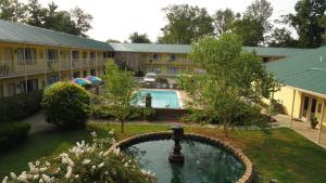 a courtyard with a fountain in front of a building at Golden Manor Inn & Suites in Muldraugh