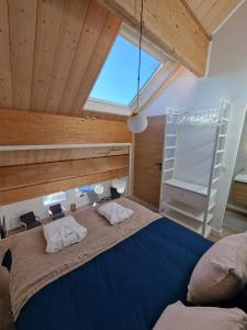 a bedroom with a large bed with a large window at Duplex type chalet dans le Jura in Morbier