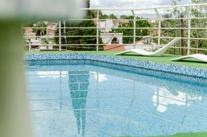 uma piscina com duas cadeiras ao lado em del Buen Ayre em Villa Carlos Paz