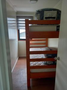 two bunk beds in a room with a window at Cabañas y Departamentos Las Palmas, Temuco Depto 1 in Temuco