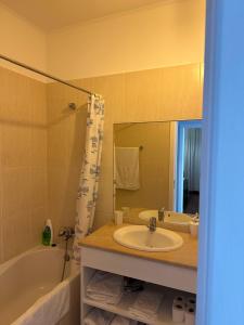 een badkamer met een wastafel, een bad en een spiegel bij Apartamentos Amarelo in Caniçal +29 foto's