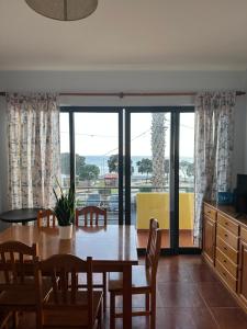 Apartamentos Amarelo في كانيسال: مطبخ وغرفة طعام مع طاولة وكراسي