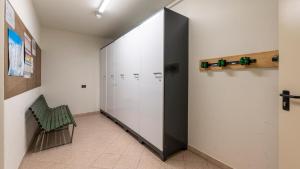 a locker room with a partition with a green chair at Bait dal Nono Filip in Livigno