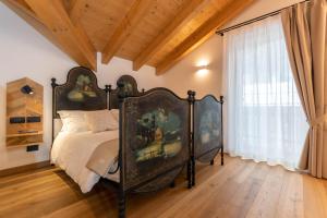 a bedroom with a bed with a painting on it at B&B El Lares - B&B L'Avez in Canale dʼAgordo