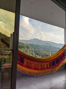 a colorful hammock on a balcony with a view at El Refugio Minca in Minca