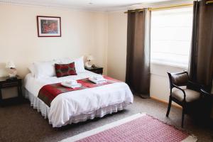 a bedroom with a bed with a red blanket and a window at Hotel Rondó in Viña del Mar