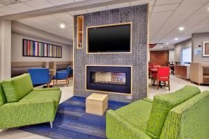 a lobby with a fireplace and a tv on a wall at Holiday Inn Express Absecon-Atlantic City Area, an IHG Hotel in Absecon