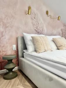 a bedroom with a bed with a pink wall at Grand Apartament in Złotów