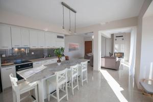 a kitchen with a large island with white cabinets at Over the horizon 3 bedroom apartment in Nafplio