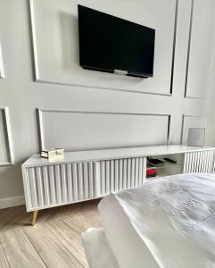 a bedroom with a tv on a wall at Grand Apartament in Złotów