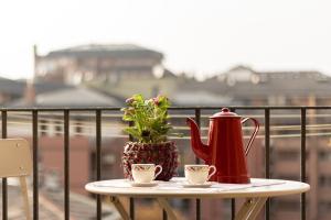 una mesa con hervidor de agua y 2 tazas en el balcón en Appartamento luminoso a 5 min da Porta Nuova en Turín