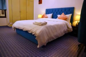 1 dormitorio con 1 cama azul y 2 toallas en Jay Ally - Boutique Hotel, en Nueva Delhi