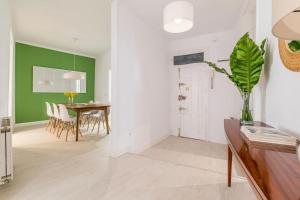 sala de estar con mesa y pared verde en Luminoso y amplio apartamento en Ópera, en Madrid