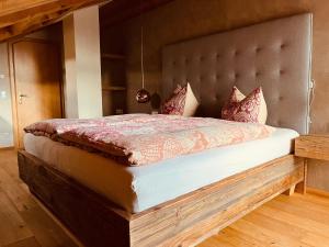 Schlafzimmer mit einem großen Bett mit einem gepolsterten Kopfteil in der Unterkunft Wally Luxus Lodge im Ferienhaus Magdalena in Mittenwald