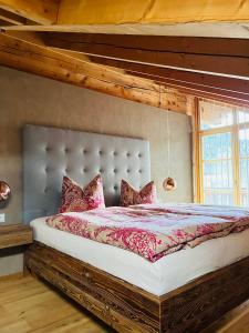 ein Schlafzimmer mit einem großen Bett und einer Holzdecke in der Unterkunft Wally Luxus Lodge im Ferienhaus Magdalena in Mittenwald