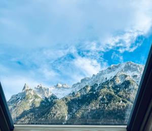 einen Blick auf eine Bergkette aus dem Fenster in der Unterkunft Wally Luxus Lodge im Ferienhaus Magdalena in Mittenwald