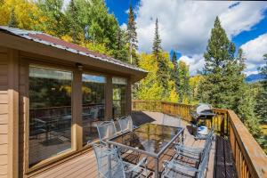 eine Terrasse mit einem Glastisch und Stühlen in der Unterkunft 389 Beaver Circle in Durango Mountain Resort