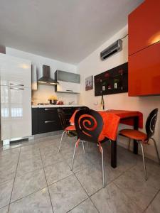 a kitchen with a red table and chairs in it at Calda e accogliente Limone in Limone Piemonte