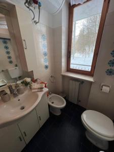 a bathroom with a sink and a toilet and a window at Calda e accogliente Limone in Limone Piemonte